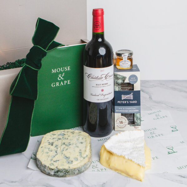 A Christmas hamper with one bottle of wine, two cheeses, crackers and honey