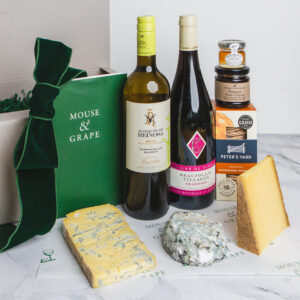 A Christmas hamper with two bottle of wine, three cheeses,